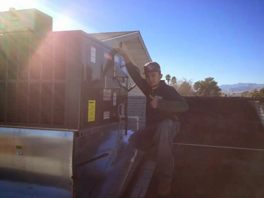 HVAC technician performing Heat Pump Repair on a rooftop unit in Nederland